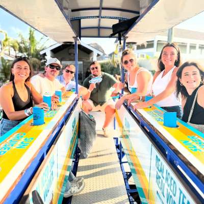 Group of people smiling on a boat with drinks on a sunny day.