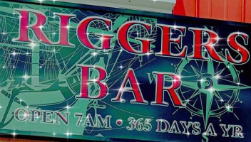 Glittery sign reading 'Riggers Bar' with nautical theme, open 7AM, 365 days a year.