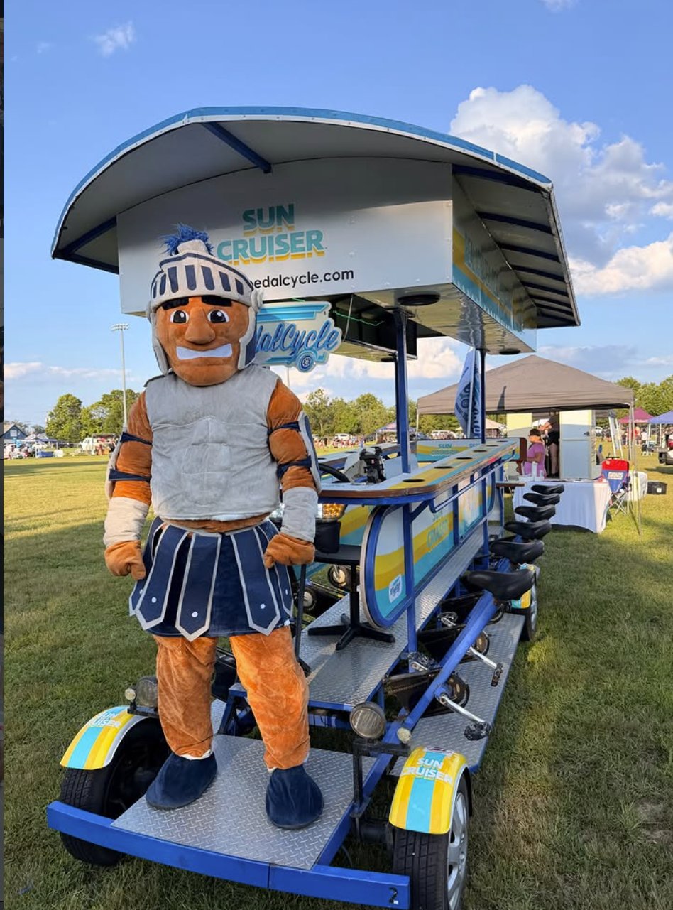 Toms River Warriors mascot standing on the PedalCycle party bike